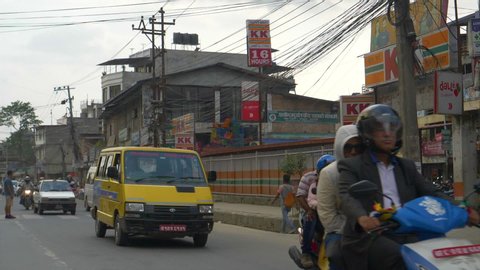 KATHMANDU, NEPAL - SEPTEMBER 2018: SLOW MOTION, CLOSE UP: Locals in old cars and on motorcycles pollute the air in Kathmandu. Crowds of local people and tourists occupy the roads in Nepali capital.