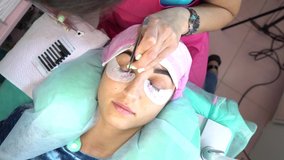 Woman master in the beauty salon work on eyelash extension to the client. Profession in the field of beauty services