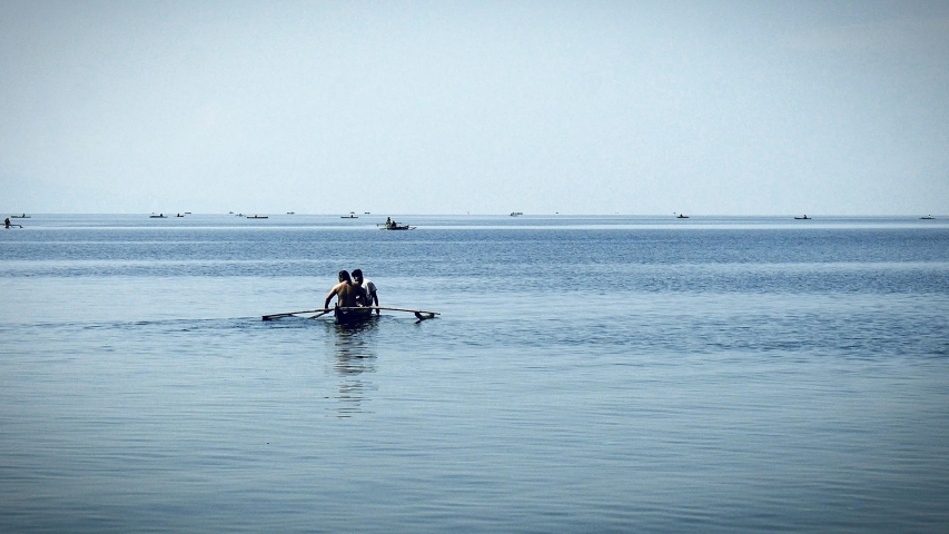 Anglers and small-fry fishermen on tiny rowboats go about finding their daily catch to bring to market at a fishing town in the Visayas region of the Philippines.