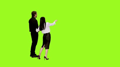 A beautiful couple, handsome man and seductive girl in love walking holding hands and looking at something on green screen background, Rear view, Chroma key, 4k shot