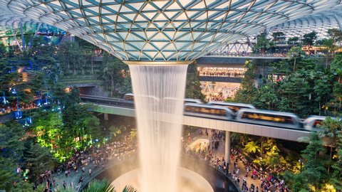 Singapore, Changi Airport, The Jewel Entertainment And Retail Center.  06,16,2019. TL/ZO Zoom Out Time lapse with monorail passenger trains passing through, transporting commuters.