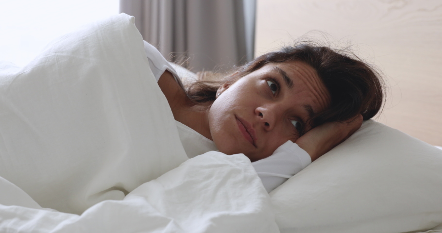 Frustrated upset young woman lying awake in bed alone trying to sleep suffer from insomnia or uncomfortable bad mattress, annoyed stressed lady insomniac feeling disturbed toss and turn in bedroom Royalty-Free Stock Footage #1032911081
