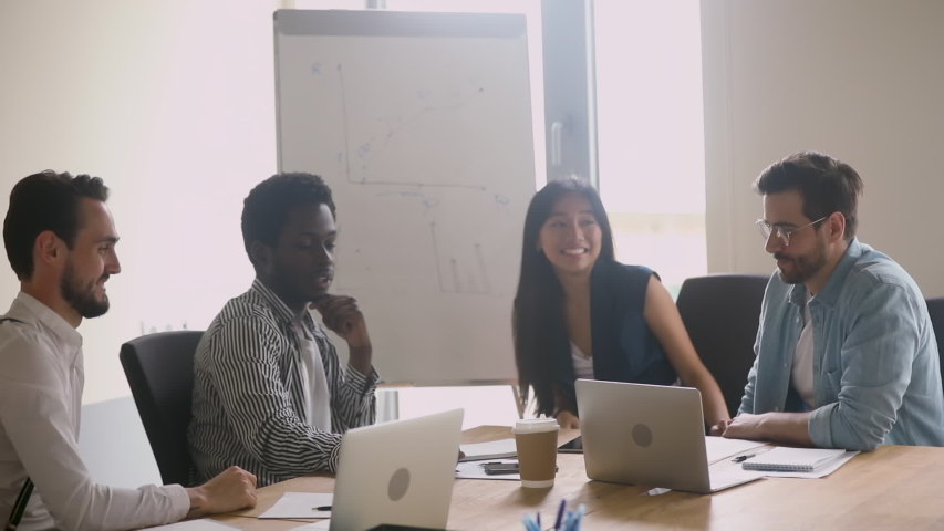 Happy successful multiethnic business team give high five sit at table, motivated diverse executives group engaged in teambuilding celebrate good teamwork result achieved corporate goals concept Royalty-Free Stock Footage #1032911195