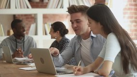 Young male mentor teacher tutor teaching helping asian female classmate intern with online computer project, diverse students talking using laptop explaining course work study together in library - Powered by Shutterstock - Get 15% off with code: PIKWIZARD15