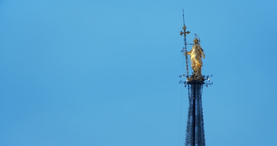 Madonnina statue on top of the Duomo in Milan, Italy. Evening - night