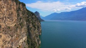 Aerial video with drone. 4k flight along steep cliffs over Lake Garda, Italy