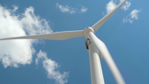 Wind generator on bright cloudy sky background
