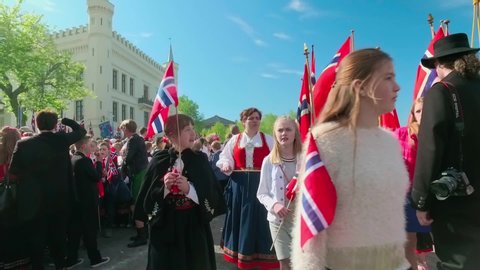 Oslo/Norway - 05/17/2016; Crowd of adults and children with Norwegian flags  and music during parade on May 17, Norwegian Constitution Day in Oslo Norway