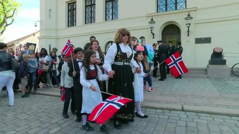 Oslo/Norway - 05/17/2016; Crowd of adults and children with Norwegian flags  and music during parade on May 17, Norwegian Constitution Day in Oslo Norway