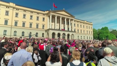 Oslo/Norway - 05/17/2016; Crowd of adults and children with Norwegian flags  and music during parade on May 17 near Royal Palace, Norwegian Constitution Day in Oslo Norway