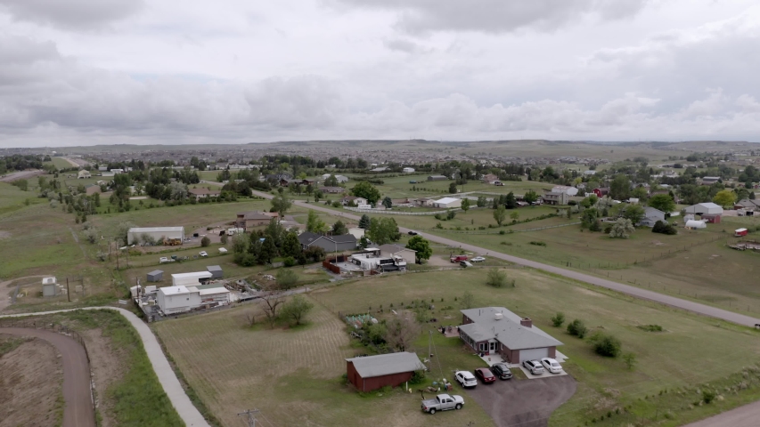 Aerial view over green farmland and horse property in Colorado