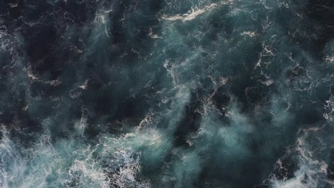 Top aerial slow motion view of surge ocean surface, beautiful foamy ocean waves of azure color