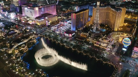 Drone flying over glowing hotels, casinos and Eiffel Tower at night. Citylife is fool of motion, neon lights and famous shows. The Strip. Las vegas. Nevada. Jul 2019. Aerial 4k.