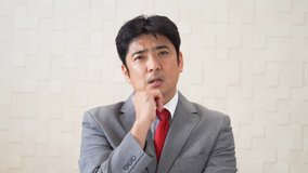 Serious Asian businessman thinking about something.