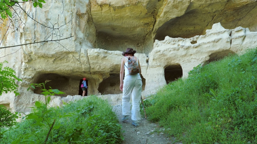 Two girls traveler girlfriend visiting the ancient cave city located high in the mountains on a plateau.