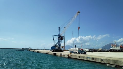 Crane is lifting a white sailor boat and placing it into the sea water. Time lapse shot. Adlı Stok Video