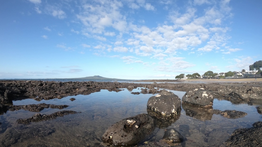Milford beach, low angle time lapse with New Zealand volcano in distance