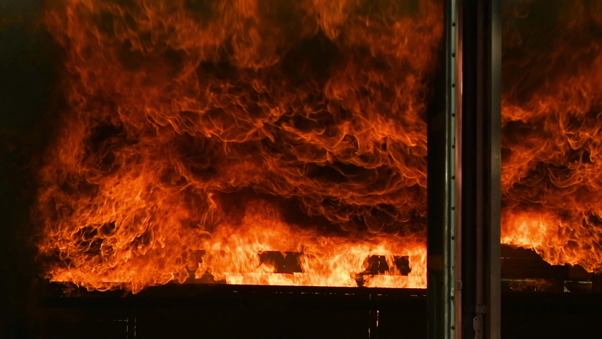 Big real fire of gas and oil explosion bursting through air.The building was burnt down.infernal fire in an industrial factory with big flame and smoke. Looping Fire Flames. Fire wall in slow motion