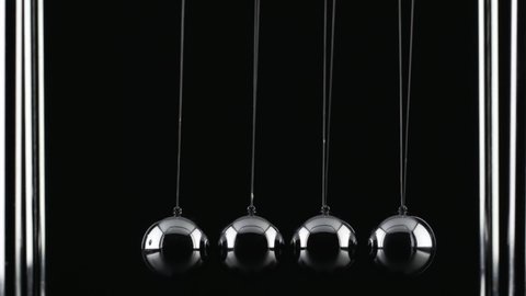 The chrome balls of a Newton’s Cradle colliding in slow motion