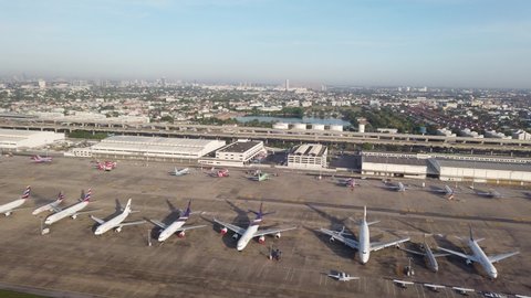 BANGKOK, THAILAND - MAY 3, 2019: Aerial top view from aircraft window with commercial airplanes parking on runway
