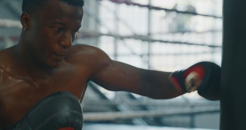 Cinematic slow motion shot of two professional young muscular shirtless male boxers are fighting  in a boxing ring. Stock Video