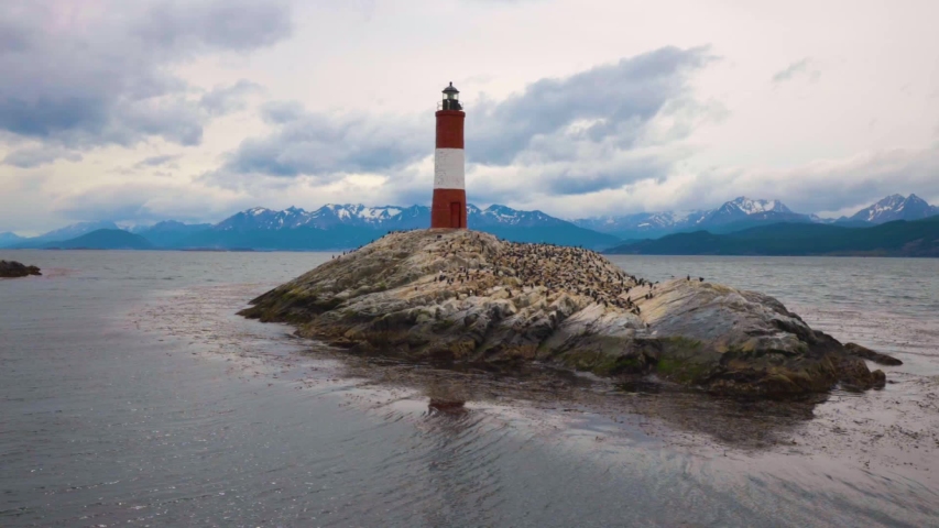 Lighthouse on small island slowmo paning shot left to right