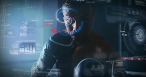 Slow motion of a professional young muscular shirtless man is practicing shadow boxing work out using latest innovative technology with augmented reality holograms in a ring.