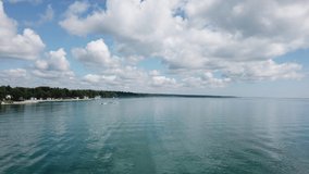 Lake Huron Coast in East Tawas Michigan on a beautiful sunny summer day with boats and water skiing.