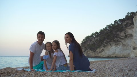 Happy family on pebble beach during summer vacation