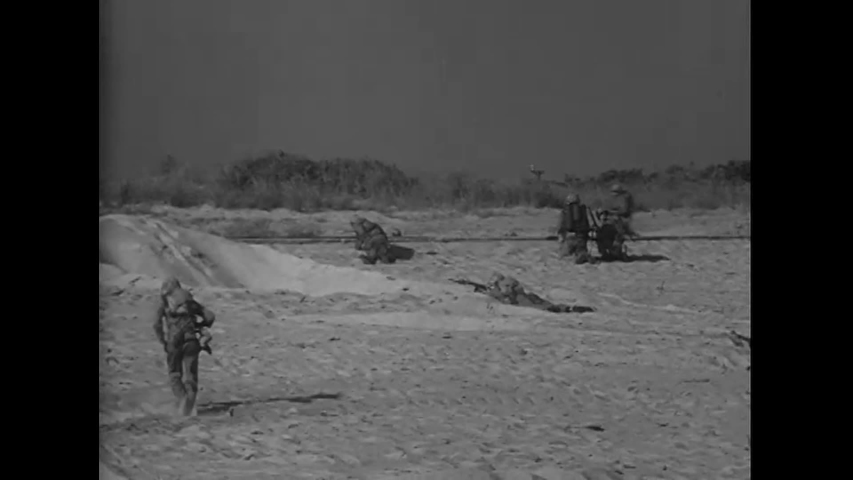 CIRCA 1943 - US Marines storm a beach on foot.