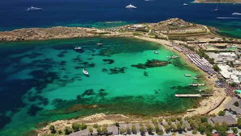 Aerial drone bird's eye view video from famous beach of Paraga with emerald clear sea, Mykonos island, Cyclades, Greece