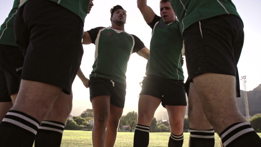Rugby team putting their hands together before the match. Rugby players cheering and ready to win.