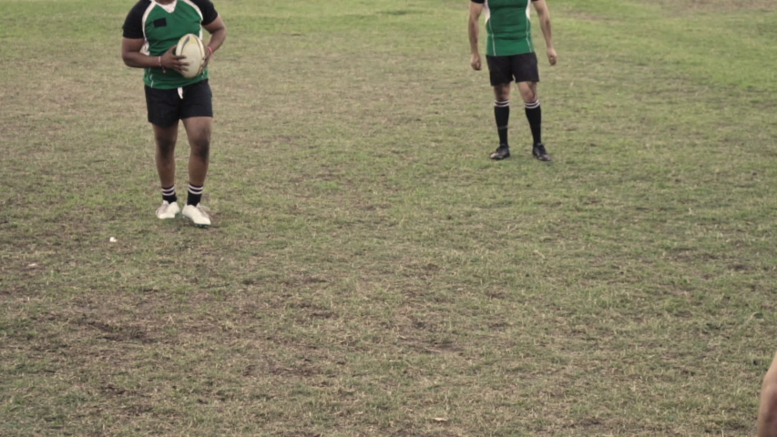 Rugby player with ball tackling the opponent during the match. Rugby players in action on the ground. Royalty-Free Stock Footage #1032990008
