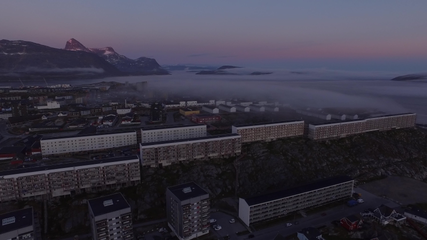 Drone timelapse footage of evening fog sweeping over the city of Nuuk, Greenland.