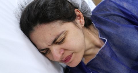 Pregnant woman at hospital feeling pain and contractions preparing for birth delivery labor