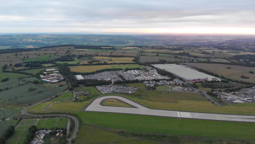 Aerial footage of the famous Leeds and Bradford airport located in the Yeadon area of West Yorkshire in the UK, typical British airport showing the runway and houses and roads around the airport