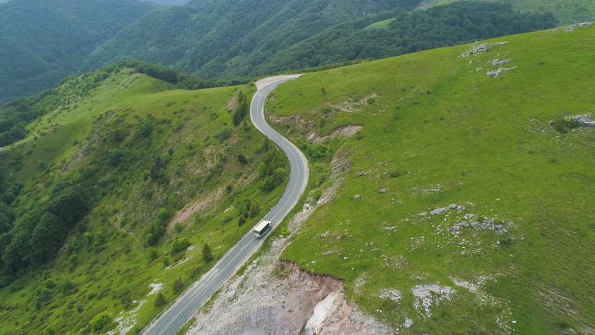 A car going trough a winding road high in the mountains