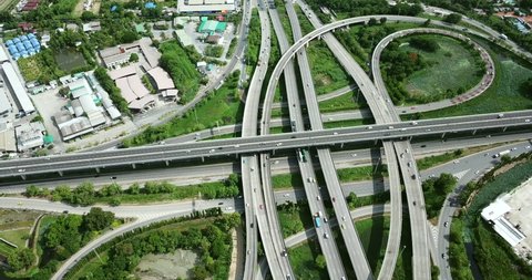 4K. Aerial view of road interchange of highway intersection with busy urban traffic speeding on the road. Junction network of transportation taken by drone.