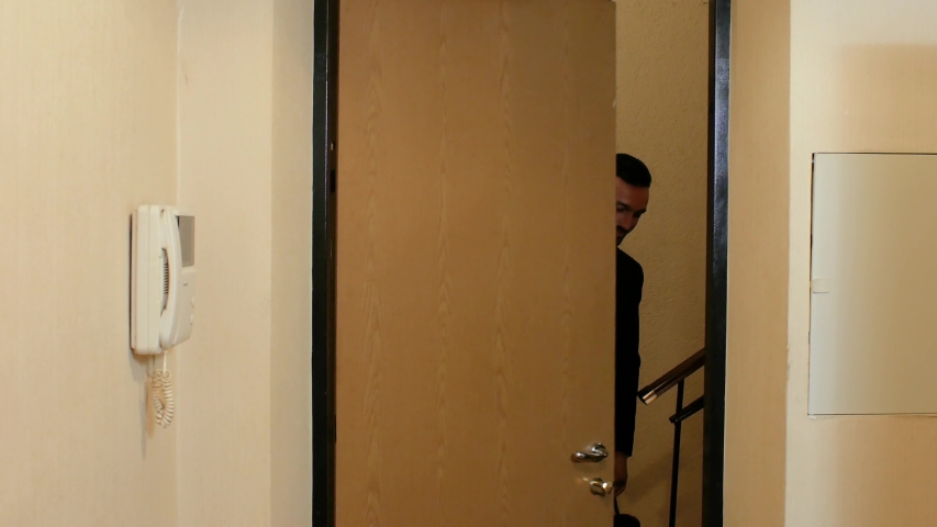 a guy with a beard in a suit and tie speaks standing in the door of the apartment, then closes the door outside. 4k. 4k video - Powered by Shutterstock - Get 15% off with code: PIKWIZARD15