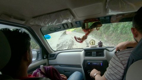 KATHMANDU, NEPAL - SEPTEMBER 2018: POV: Scary rough car drive along an unpaved trail in the Nepali countryside. Sitting in backseat of a jeep as you drive down a poorly maintained road to Tibet.