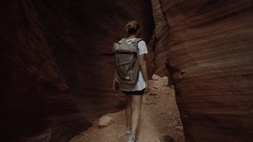 TRACKING Female hiking in slot canyon in Arizona, USA. Unusual colorful sandstone formations are popular destination for hikers. 4K UHD RAW graded footage