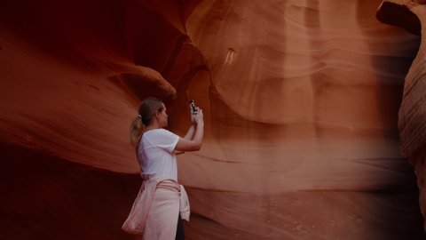 Caucasian female taking pictures with her phone in Antelope Canyon, Arizona. 4K UHD RAW edited footage