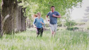 Crane Shot Of Couple Exercising Running Through Countryside Field - Powered by Shutterstock - Get 15% off with code: PIKWIZARD15