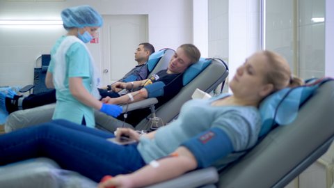Nurses take blood from volunteers at a modern donor center.