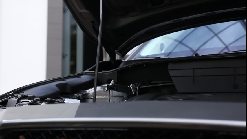Man pouring liquid into car washer fluid reservoir, closeup
