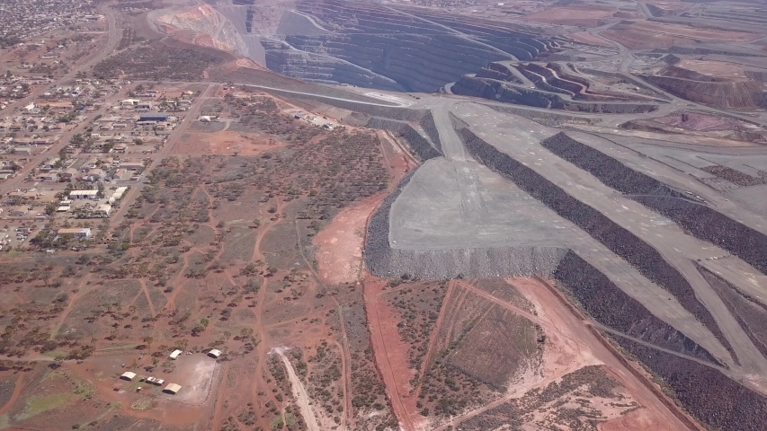 The gigantic mine Kalgoorlie extends to the horizon. Aerial view of the canyon-like mine with its huge trucks in the south west of australia
