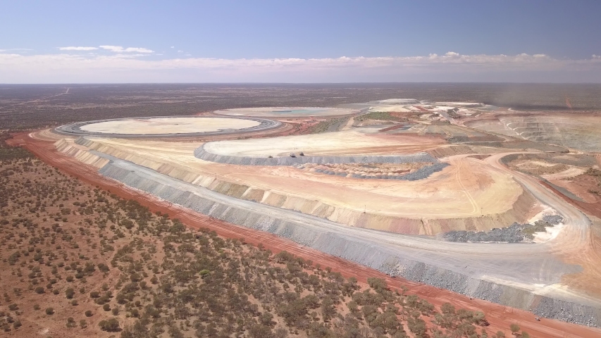 The gigantic mine Kalgoorlie extends to the horizon. Aerial view of the canyon-like mine with its huge trucks in the south west of australia
