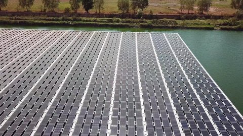 Drone flying above some workers on a floating solar PV panels on a pond in China. China is one of the countries with more investments into green energy technologies