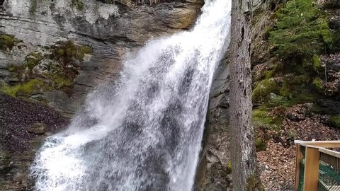 Close up Slow motion shot of water going down a waterfall in a forest