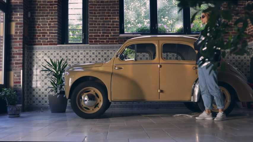 young hipster traveler girl walking on parking and waiting for family. vintage car on parking